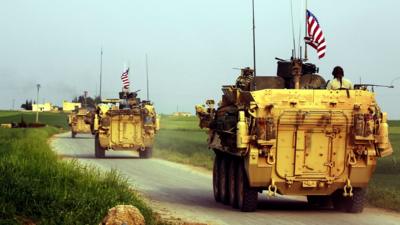 US forces accompanied by YPG fighters drive their armoured vehicles in northern Syria in April 2017