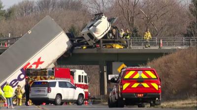 FedEx truck hanging from a bridge