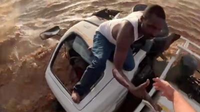 Driver holding his hand out to helicopter rescuer