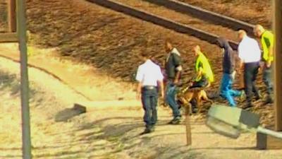 Migrants are escorted off Eurotunnel tracks