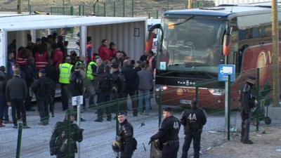 Migrants board a coach