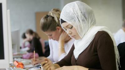 A woman in the workplace wearing a headscarf