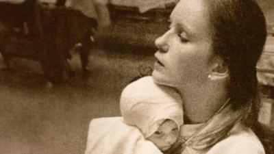 Susan Berger cuddles infant Amanda Scarpinati in 1977