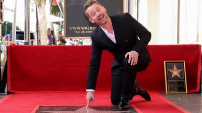 Macaulay Culkin points at his Hollywood Walk of Fame star