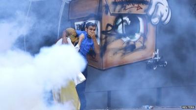 A couple runs away from tear gas used by police to disperse demonstrators during a protest in Istanbul