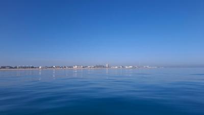 Deep blue sky with deep blue sea and a thin horizontal slice of land cuts through the middle