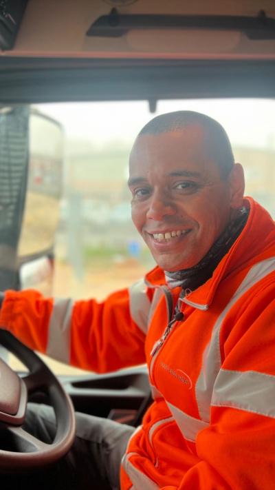 Man in high vis drives a car