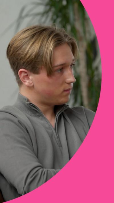 Max Murray sits with his arms crossed. He has blond hair styled as curtains and wears a grey top