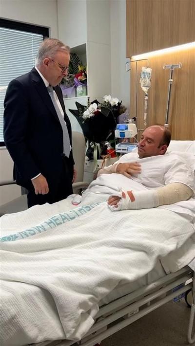 Anthony Albanese standing by man in a hospital bed. 