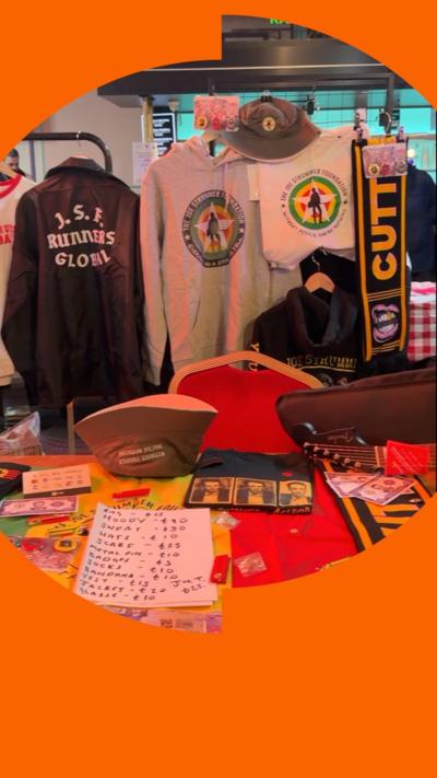 A table with merch on it, including hats sweaters and scarves