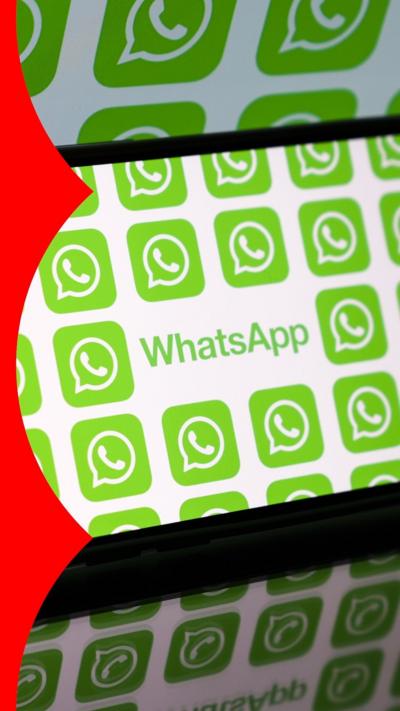 A smart phone on its side, with its screen displaying the world WhatsApp and multiple WhatsApp logos.