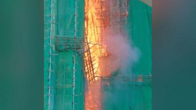 Fire in Wang Cheong House surrounded by green building covers