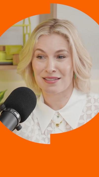 A woman with bobbed blonde hair talks into a microphone