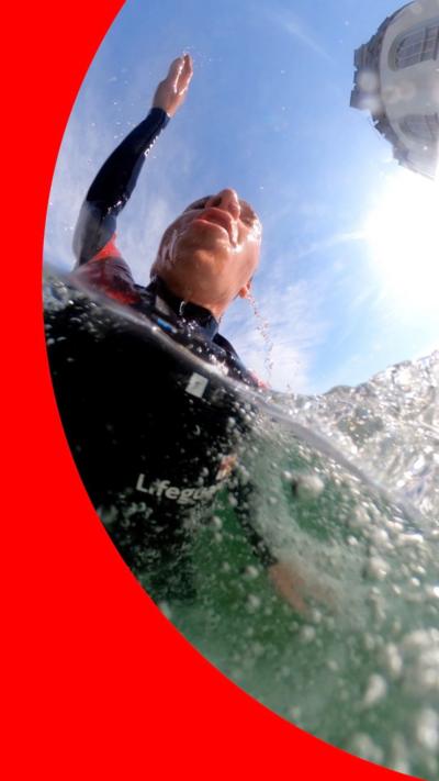 Man in a wetsuit in the sea, with his head above water