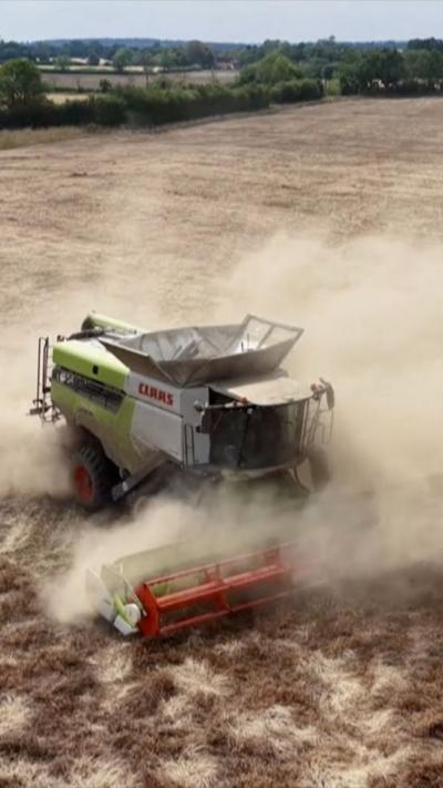 A combine harvester in a dusty field