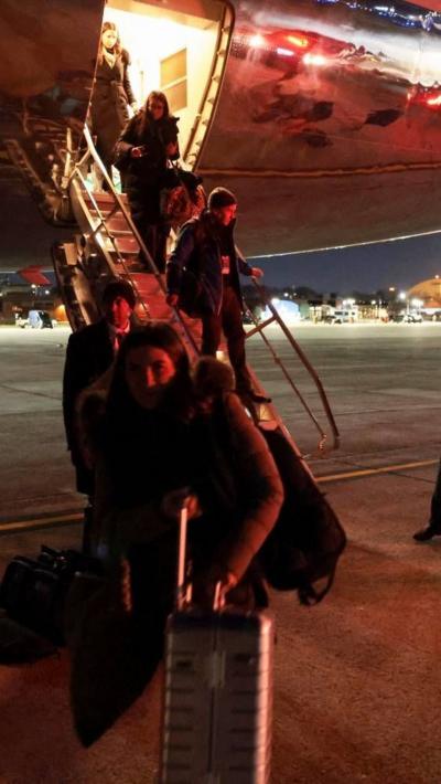Members of the media deboard Air Force One in the middle of the night.