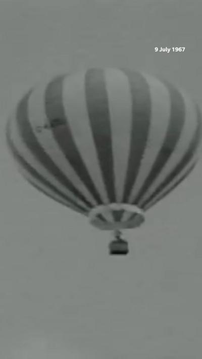 Black and white image of hot air balloon in the air