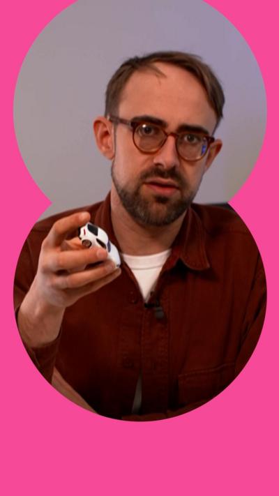 A man with short, brown hair and glasses holds a toy car