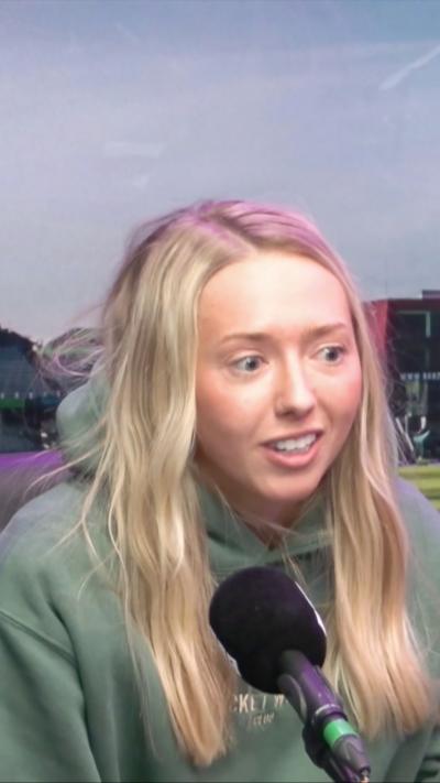 Woman with long blonde hair wearing a green hoodie