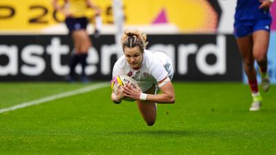 Ellie Kildunne in England kit flying through the air holding the rugby ball as she scored a try in the semi-final