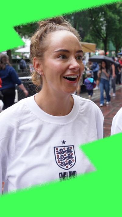 A woman wearing an England football t-shirt smiling on a Boston street