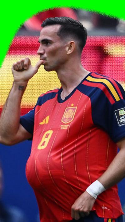 Fabian Ruiz with the ball in his shirt making a thumb-sucking gesture to celebrate scoring the opener for Spain.