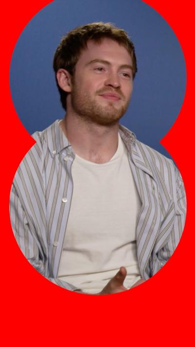 Actors Kit Connor is wearing a vertical striped shirt over a white t-shirt.