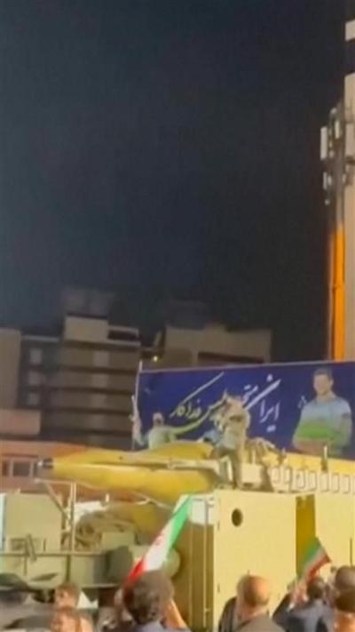 People stood on top of an apparent missile on a truck