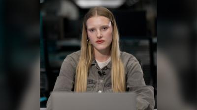 Morven McKinnon - a young woman with long straight blonde hair, sitting at a desk with an open laptop in front of her