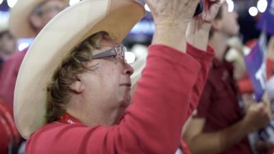 Woman crying as she holds up Trump sign