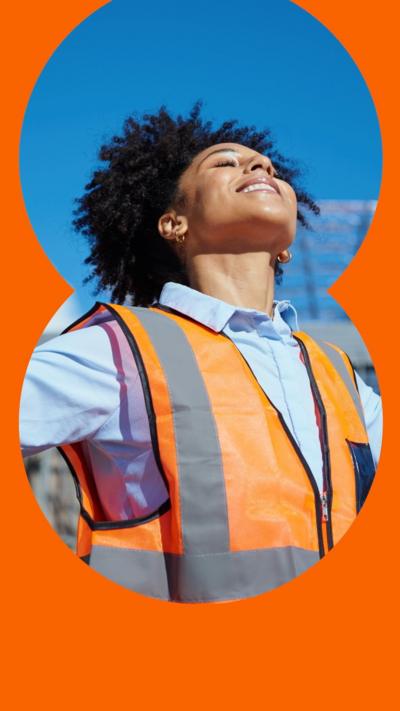 A woman wearing a blue shirt and orange bib with her arms outstretched