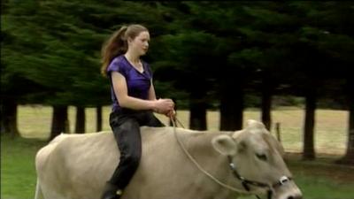 Hannah Simpson riding a cow