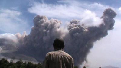 Man standing in front of ash cloud