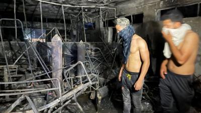 People look at damage caused by fire