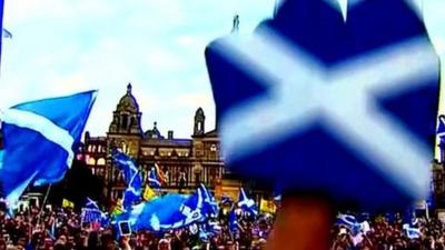 Rally in Scotland, people waving Saltires