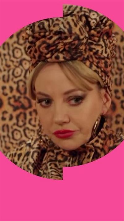 Mandy sits on a sofa. Her leopard print outfit matches it so she blends in.