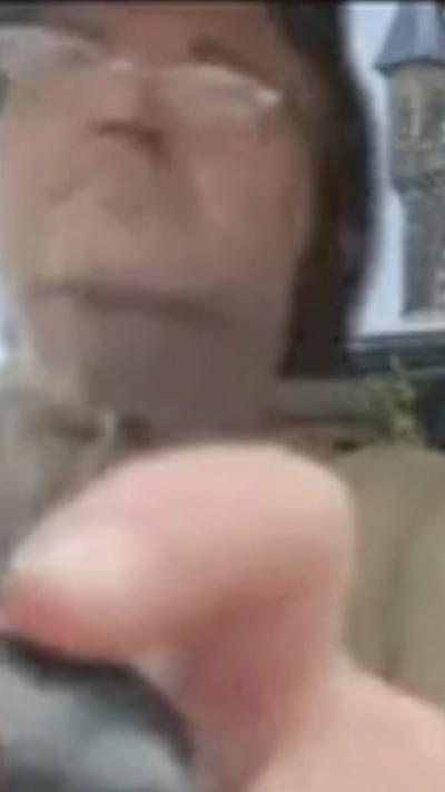 A man holding a gear stick in front of a Teams meeting background of a castle