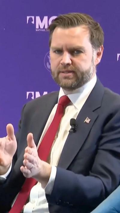 JD Vance wearing a dark suit and red tie