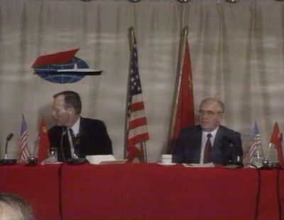 George Bush and Mikhail Gorbachev sitting behind desk