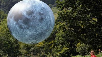 girl looking at moon balloon