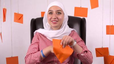 A woman opens an orange envelope