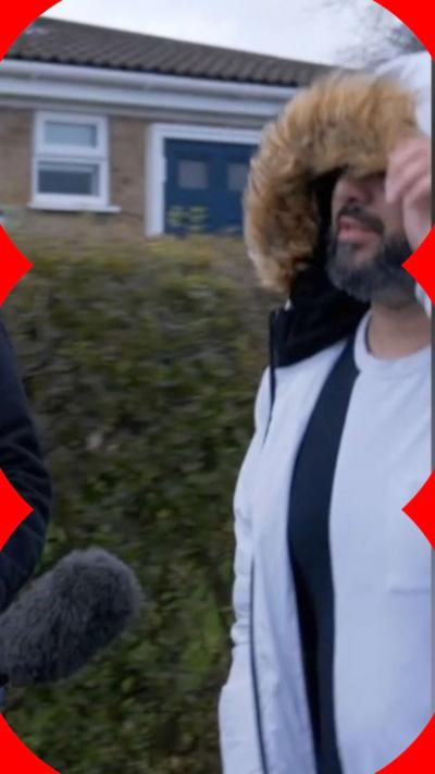 Man with hood up in front of microphone