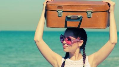 Woman with a suitcase on her head