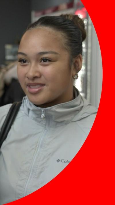 A student, with her hair in a bun, speaking to the camera
