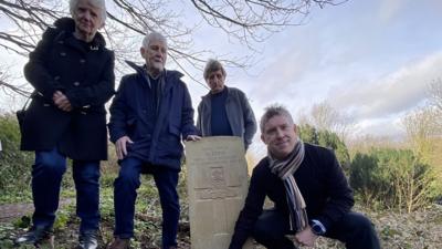 People stood in front of a grave