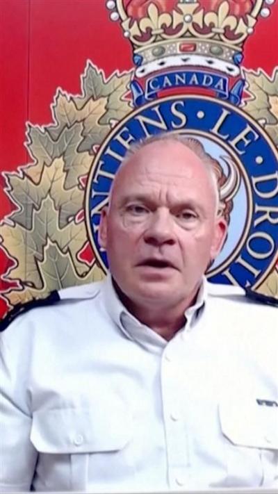 Ken Floyd sitting in front of a red banner at a video press conference