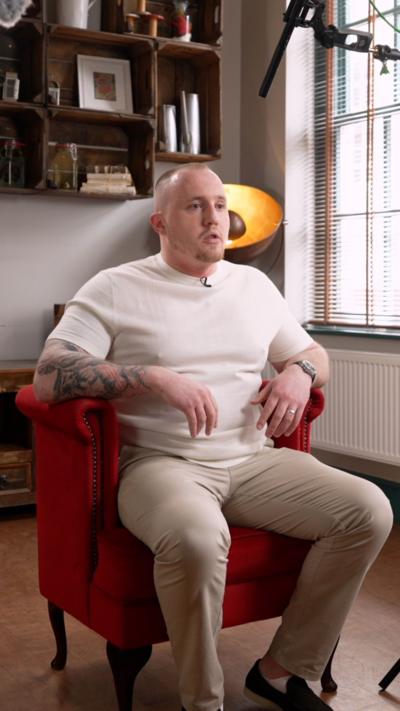 A man in a white top with short hair