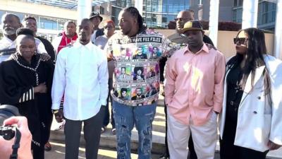 Michael Corey Jenkins and Eddie Terrell Parker with their families walking to court