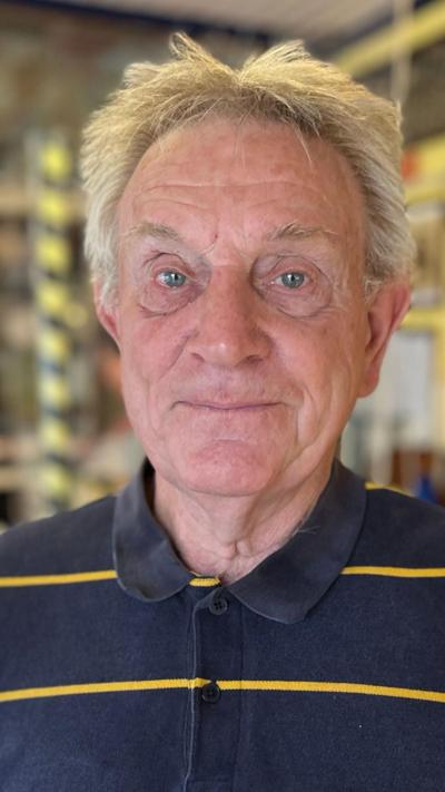 Close up of elderly man with white hair wearing blue striped top