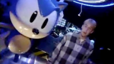 Reporter Chris Rogers standing beside a giant Sonic the Hedgehog